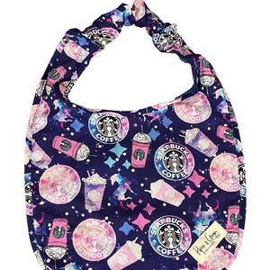 Könnte beinhalten: Eine blaue Stofftasche mit einem Galaxie-Druck, der Starbucks-Kaffeebecher, Sterne und Einhörner zeigt. Der Text "I am a Unicorn" und "Starbucks Coffee" wird im gesamten Druck wiederholt.
