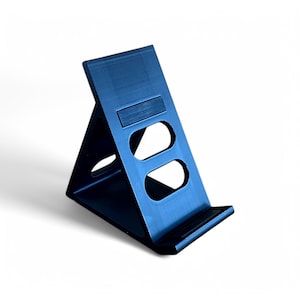 Puede incluir: Un soporte para teléfono de plástico negro con dos recortes para sujetar un teléfono en modo vertical u horizontal.