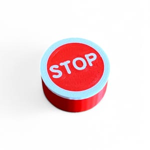 May include: A red and white round stop sign with the word "STOP" printed in white letters.