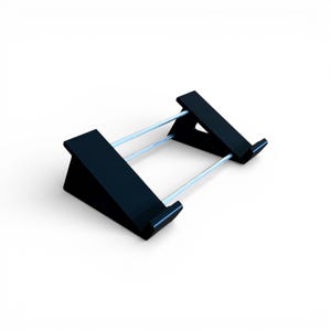 May include: A black, angled stand with two silver support bars. The stand is designed to hold a tablet or other electronic device. The stand is made of a solid material and has a minimalist design.