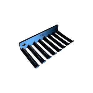 Puede incluir: Peine de metal negro con siete dientes, diseñado para peinar el cabello. El peine presenta un mango plano y rectangular con un borde curvo y una serie de dientes espaciados uniformemente. El peine está hecho de un material duradero.