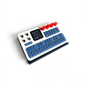 May include: A white synthesizer featuring a black screen displaying DDS PIANO 2, four red rotary knobs, and a grid of blue rectangular buttons. The device includes black control knobs labeled MASTER, SELECT, PRESETS, and ALGORITHMS.