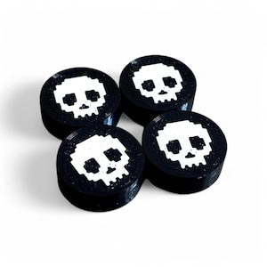 May include: Four black round gaming buttons with a white pixelated skull design.