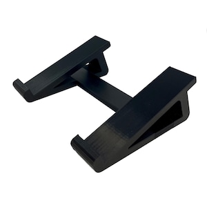 May include: A black plastic laptop stand with two angled surfaces that elevate the laptop for better ergonomics.