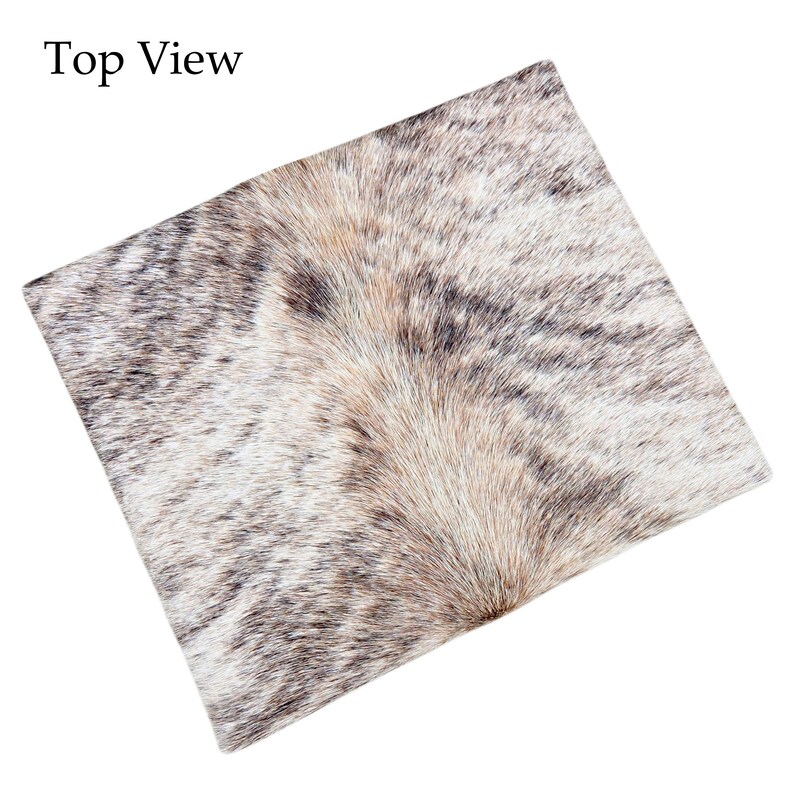 May include: Top view of a square cowhide pillow with a natural brindle pattern. The pillow features a mix of brown, white, and gray tones, creating a textured and organic appearance. The text "Top View" is in the top left corner.
