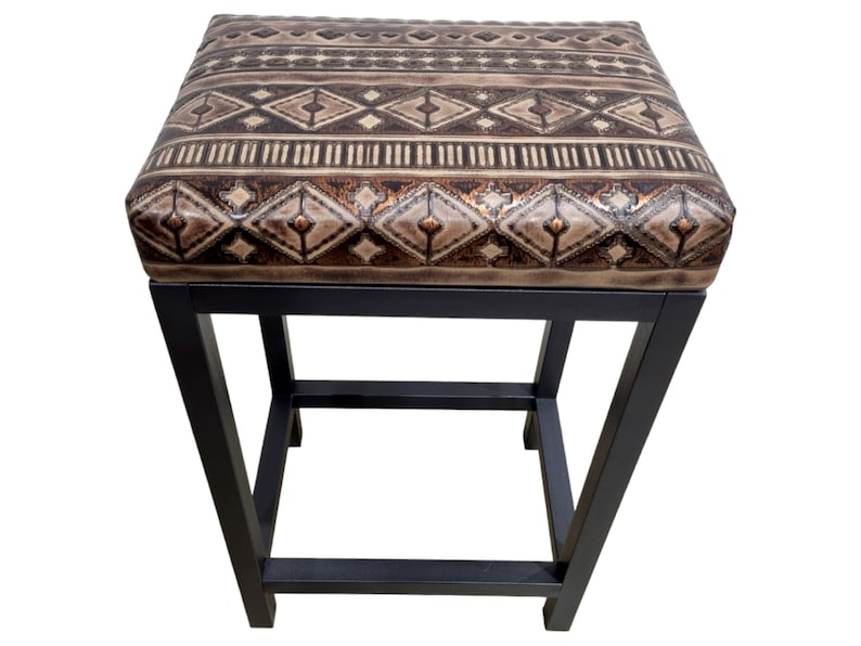 May include: A black metal stool with a brown and beige patterned upholstered seat.
