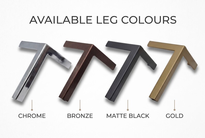 May include: Four L-shaped furniture legs arranged in a row, labeled with the text AVAILABLE LEG COLOURS. The finishes from left to right are shiny chrome, dark bronze, matte black, and gold. Each leg features a two-pronged design.