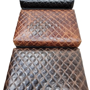 May include: Three quilted leather storage ottomans in black, brown, and dark brown.