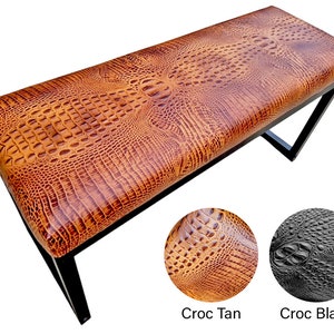 May include: A brown leather bench with a crocodile pattern. The bench has a black metal frame. The bench is shown in two different colors: tan and black.