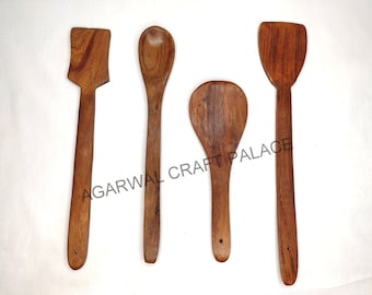 Puede incluir: Cuatro utensilios de cocina de madera: una espátula, una cuchara, una cuchara para servir y una espátula plana. Los utensilios son todos de madera natural y tienen un color marrón.