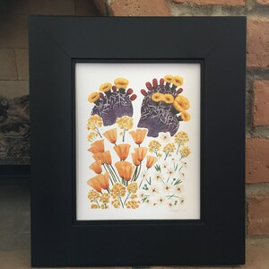 May include: A framed print of a botanical illustration featuring a cluster of orange and yellow flowers, including prickly pear cactus blossoms, against a white background.