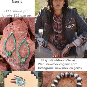 May include: Southwest Chic jewelry featuring turquoise and silver earrings and a bracelet. The earrings are teardrop shaped with turquoise beads and silver accents. The bracelet is made of silver beads. The image also includes a painting of a bear with turquoise accents.