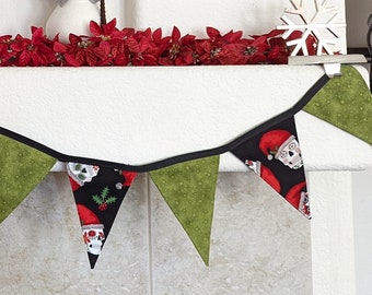 Può includere: Decorazione natalizia per camino con uno striscione con motivi di Babbo Natale e triangoli verdi. Il camino è decorato con stelle di Natale, pupazzi di neve, alberi di legno e un cartello incorniciato con la scritta "Tis the Season to be Jolly."