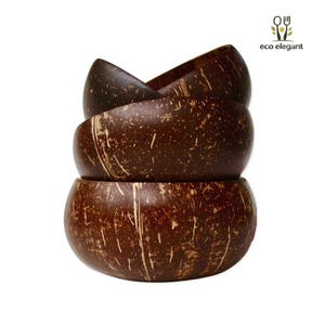 May include: A stack of four dark brown coconut bowls. The bowls have a smooth, rounded shape with a natural, textured surface. The bowls are stacked on top of each other, showcasing their varying sizes and the natural grain of the coconut.