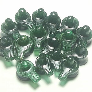 Puede incluir: Un grupo de 15 colgantes de Shiva Lingam de cristal verde. Los colgantes tienen la forma de un Shiva Lingam, un símbolo del Señor Shiva en el hinduismo.