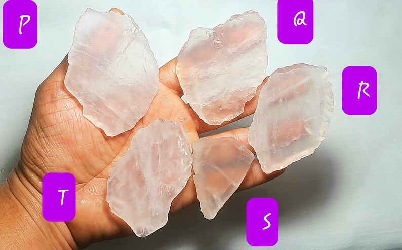 May include: Six pieces of clear, pale pink, translucent, natural rose quartz crystals. The crystals are irregularly shaped and have a smooth, polished surface.