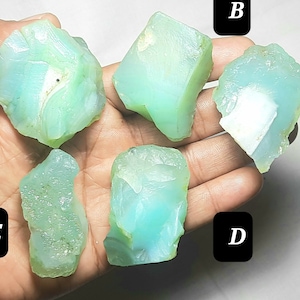 May include: Five pieces of green and blue opal rough, labeled A through E.