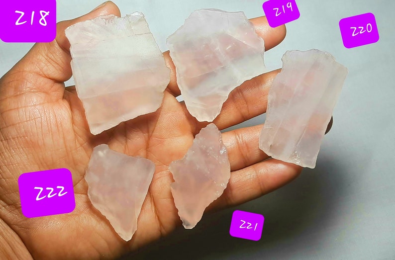 May include: Six pieces of clear, translucent, pink rose quartz crystals. The crystals are various shapes and sizes. The crystals are labeled with numbers: Z18, Z19, Z20, Z21, Z22, and Z22.