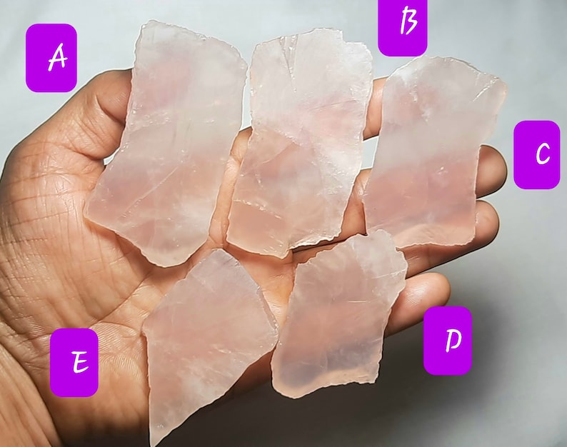 May include: Five pieces of pink rose quartz, labeled A, B, C, D, and E. The quartz is translucent and has a natural, rough edge.