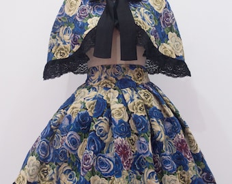 Puede incluir: Una falda de estampado floral azul y blanco con ribete de encaje negro y una capa a juego con un lazo negro. La falda y la capa están en un maniquí. El texto "Glitter tale custom size EGL fashion" está en la parte inferior de la imagen.