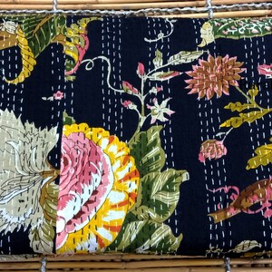 May include: Black kantha quilt with a floral pattern in shades of pink, yellow, green, and brown. The quilt is hand-stitched with white thread and has a traditional Indian design.