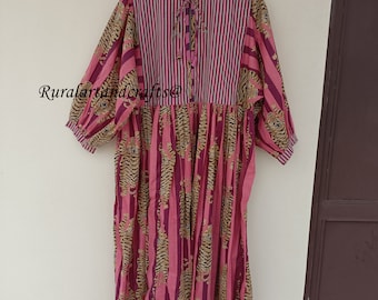 May include: A pink and brown cotton dress with a tiger print and striped bodice. The dress has a gathered skirt and 3/4 sleeves.