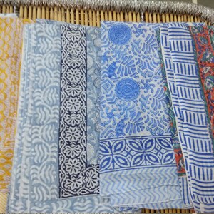 May include: Five different fabric swatches with various blue and white patterns. The swatches are arranged horizontally and are all made of a soft, lightweight fabric.
