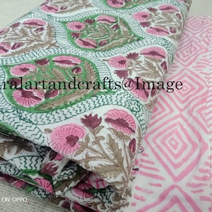 Pu&ograve; includere: Due pezzi di tessuto con motivi floreali. Un pezzo &egrave; bianco con disegni floreali verdi e rosa. L'altro pezzo &egrave; bianco con motivi a rombi rosa e bianchi. Il testo "Ruralartandcrafts@Image" &egrave; visibile sul tessuto.