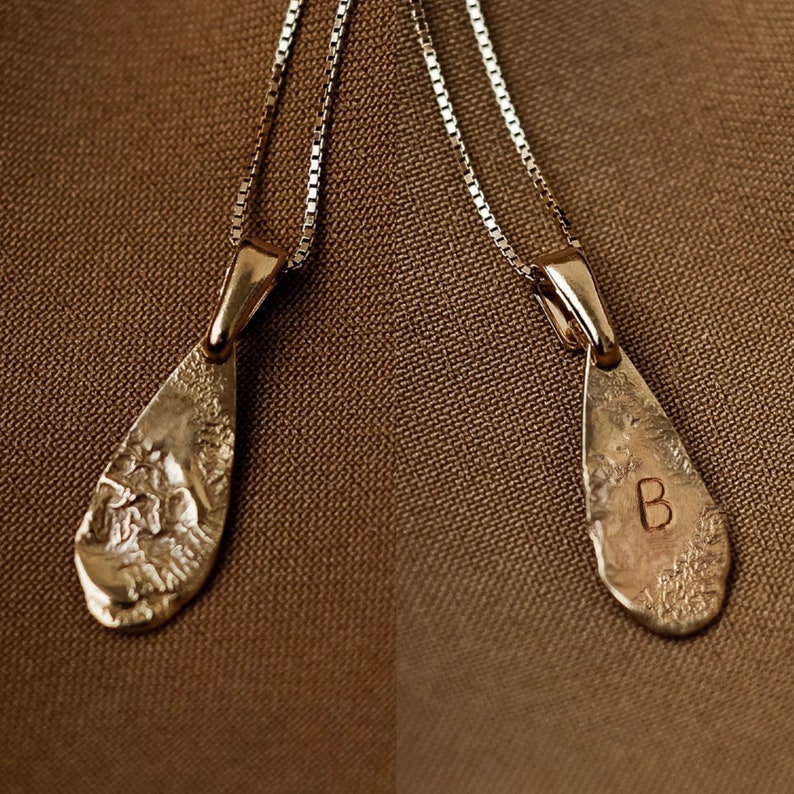 Peut inclure: Deux colliers en or avec des pendentifs en forme de larme. Les pendentifs sont textur&eacute;s et ont une finition martel&eacute;e. Un pendentif porte la lettre "B" grav&eacute;e.
