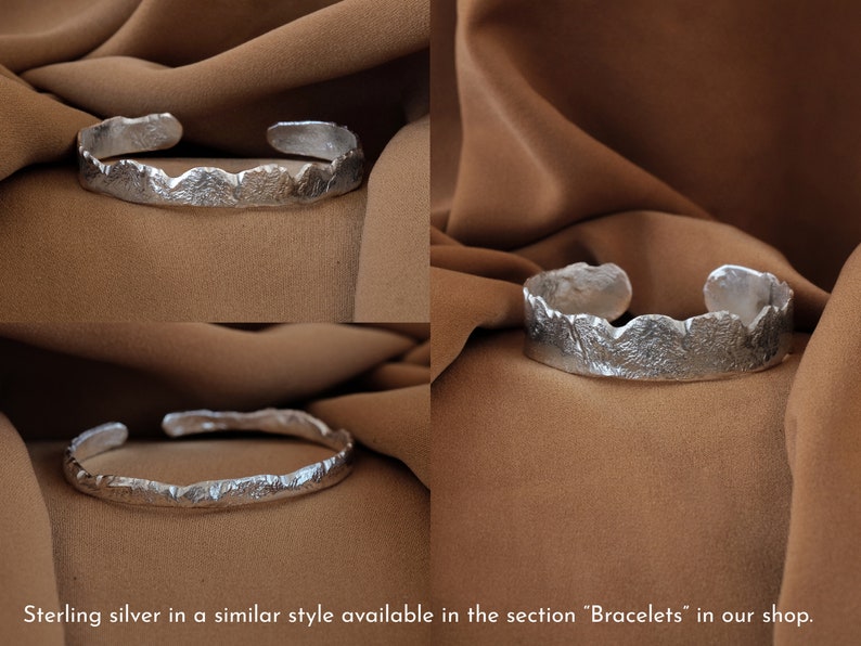 May include: A silver bracelet with a textured, organic design. The bracelet is open and has a slightly curved shape.