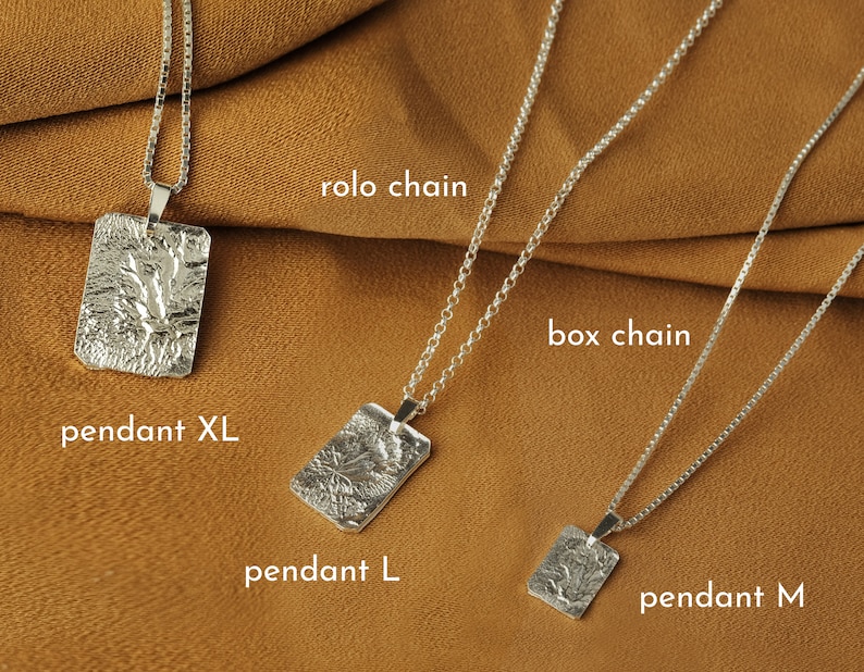 May include: Three silver necklaces with different chain styles and pendant sizes. The top necklace features a rolo chain and a large pendant labeled "pendant XL". The middle necklace features a box chain and a medium pendant labeled "pendant L". The bottom necklace features a box chain and a small pendant labeled "pendant M".