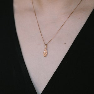Peut inclure: Un collier en cha&icirc;ne dor&eacute;e avec un pendentif en forme de larme textur&eacute;.