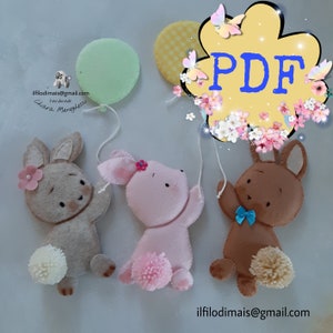Può includere: Tre giocattoli di coniglio in feltro che tengono palloncini. I conigli sono marroni, rosa e marrone chiaro. I palloncini sono verdi, gialli e rosa. Il testo "PDF" è in una nuvola gialla con fiori rosa. Il testo "ilfilo di mais@gmail.com" è in fondo all'immagine.