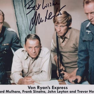 Peut inclure: Photographie vintage de quatre hommes, une scène du film "Von Ryan's Express". L'image comprend des signatures et le titre du film. Les hommes sont vêtus d'uniformes militaires et de tenues décontractées, avec des expressions sérieuses.