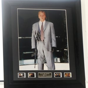 Op de afbeelding: Een ingelijste foto van Val Kilmer als een personage uit de film Heat. De foto is gesigneerd door Val Kilmer. De lijst bevat vijf kleinere foto's uit de film.