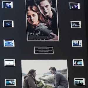 Pode incluir: Uma moldura preta com o cartaz do filme Twilight, uma imagem estática das duas personagens principais ao ar livre e oito pequenas tiras de filme dispostas verticalmente nas laterais. Uma placa central diz MOVIE FAVOURITES SCREEN RUN MOVIE FRAMES LIMITED EDITION.