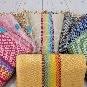 May include: A collection of colorful Turkish towels with geometric patterns. The towels are arranged in a circle with the ends of the towels overlapping. The towels are made of cotton and have a soft, absorbent texture.