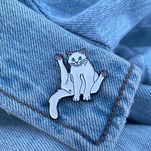 Weiße Katze Emaille Pin - Sitzendes weißes Kätzchen Anstecker - Leckt sich Kitty Anstecker - Cute Hillarious Pussycat Badge - Cuddlepaws Smudge Grumpy Cat