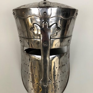 Peut inclure: Casque de croisé médiéval argenté et poli. Le casque présente une croix sur le devant et est riveté. La zone du visage comporte une fente horizontale pour la vision et de petits trous de ventilation.