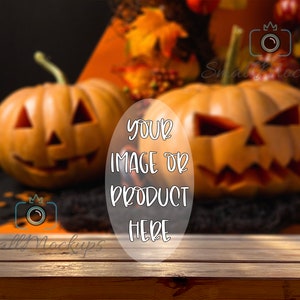 Könnte beinhalten: Zwei geschnitzte Jack-o'-Lantern-Kürbisse mit gruseligen Gesichtern auf einem Holztisch. Die Kürbisse sind scharf, während der Hintergrund verschwommen ist. Der Text "YOUR IMAGE OR PRODUCT HERE" ist über das Bild gelegt.