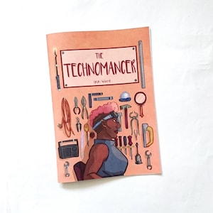 May include: A comic book titled "The Technomancer" by Izzi Ward. The cover features a stylized illustration of a person with pink hair and goggles, surrounded by tools. The background is a light orange color.