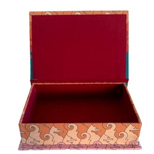 May include: Open rectangular box with a hinged lid. The exterior features a repeating pattern of seahorse-like figures in orange and cream against a peach background. The interior is lined with a deep red material. The box is open, revealing its empty interior.