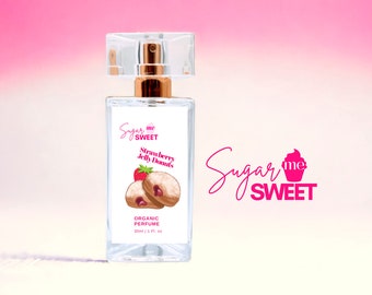 May include: A clear rectangular perfume bottle with a gold-colored atomizer and a clear cap. The label features the text "Sugar me Sweet" and "Strawberry Jelly Donuts" with an illustration of a strawberry and donuts. The bottle contains 1 fl oz of organic perfume.