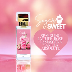 May include: A perfume bottle with a gold cap and a pink label featuring the text "Bubbly Lychee." The label also displays a lychee drink illustration and lychee fruit. The background is a gradient of pink and peach with the words "Sugar Me Sweet."