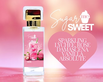May include: A perfume bottle with a gold cap and a pink label featuring the text "Bubbly Lychee." The label also displays a lychee drink illustration and lychee fruit. The background is a gradient of pink and peach with the words "Sugar Me Sweet."