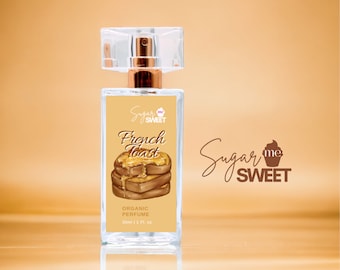 May include: A rectangular perfume bottle with a clear cap and gold-colored accents. The label features the text "French Toast" above an illustration of stacked toast with syrup. The brand name "Sugar Me Sweet" is also displayed.