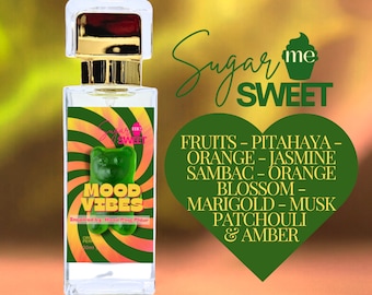 May include: A clear perfume bottle with a gold cap and a label featuring a green gummy bear and the words "MOOD VIBES." The label also lists fragrance notes like pitahaya, orange, jasmine, and amber. The background is a gradient of gold and green.