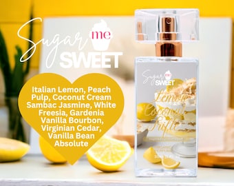 May include: A clear perfume bottle with a gold-colored top and a clear cap. The label reads "Sugar Me Sweet Lemon Coconut Trifle" with a picture of a lemon dessert. The ingredients are listed on a yellow heart-shaped graphic.