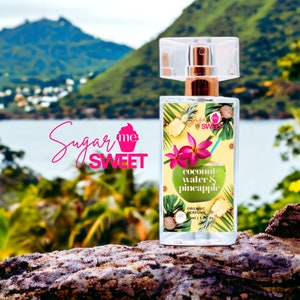 May include: A rectangular perfume bottle with a clear cap and gold-colored sprayer. The label features a tropical design with a green coconut, pink flowers, and pineapple. The text "Sugar Me Sweet" is in pink cursive.