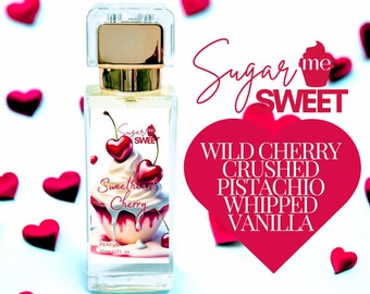 May include: A rectangular perfume bottle with a gold cap and a label featuring a cupcake with cherry hearts. The bottle is labeled "Sweetheart Cherry" and "Sugar Me Sweet". The background has red heart decorations.